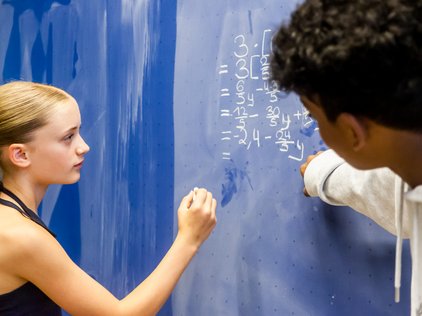 Schülerin rechnet an der Tafel