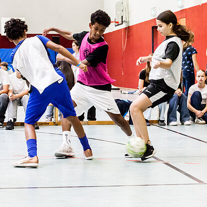 Schüler und Schülerin beim Hallenfußball
