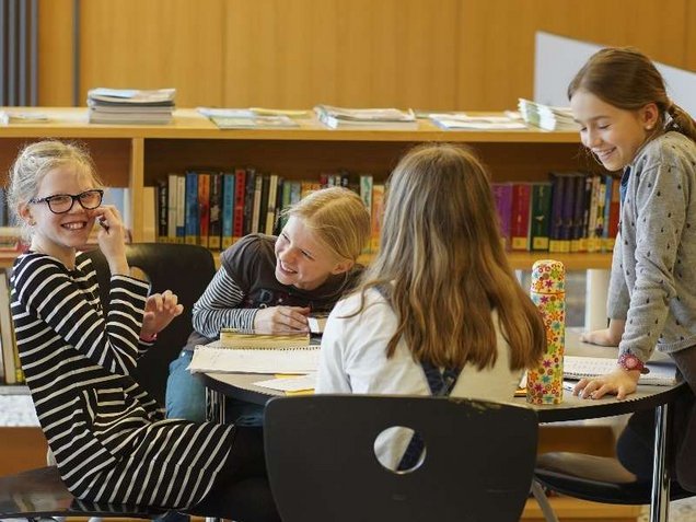 Schülerinnen machen gemeinsam Hausaufgaben in der Bibliothek