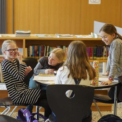 Schülerinnen im Austausch in der Schulbibliothek