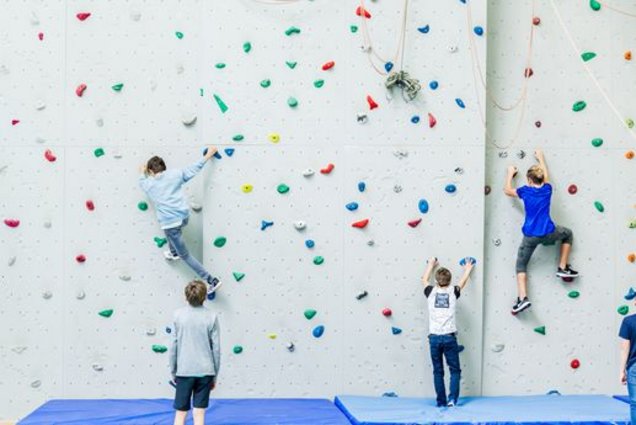 SchülerInnen klettern an der hauseigenen Kletterwand.