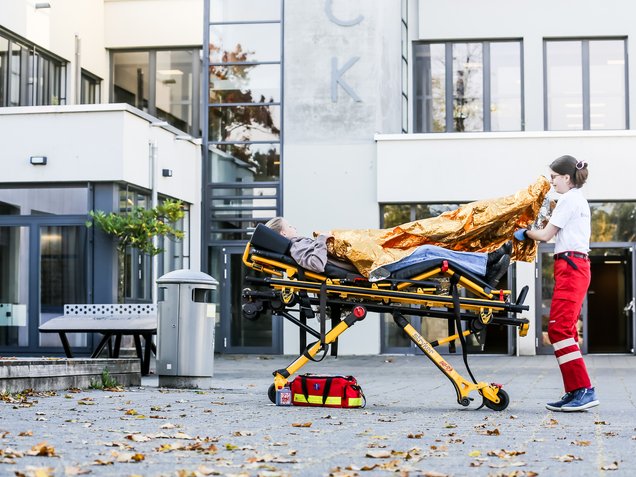 Schulsanitäterin verarztet Schülerin