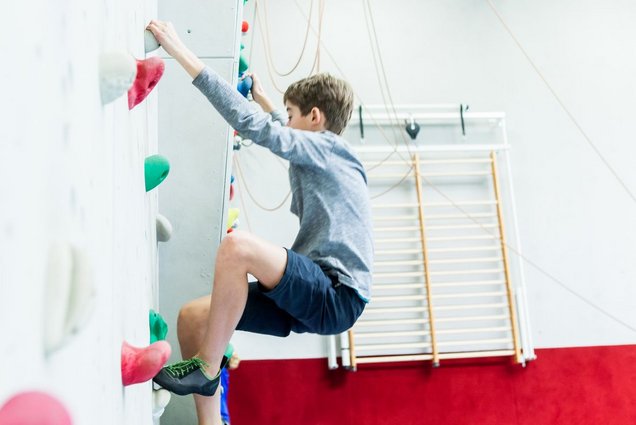 SchülerInnen klettern an der hauseigenen Kletterwand.