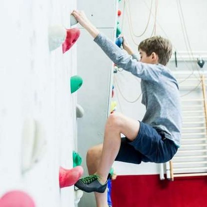 Schüler klettert an der hauseigenen Kletterwand.