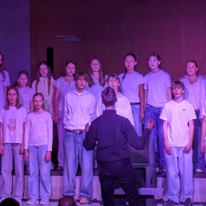 Auftritt des Mittelstufenchors in der vollen Aula des Rotteck-Gymnasiums beim Schulkonzert