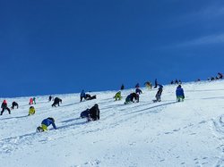 Schüler klettern am Schneehang