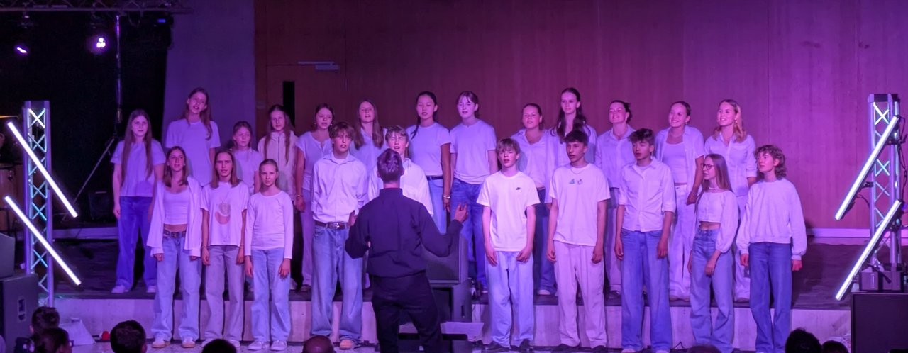 Auftritt des Mittelstufenchors in der vollen Aula des Rotteck-Gymnasiums beim Schulkonzert