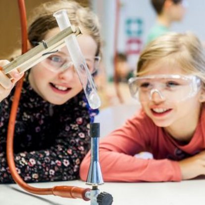 Schüler und Schülerin arbeiten mit dem Bunsenbrenner