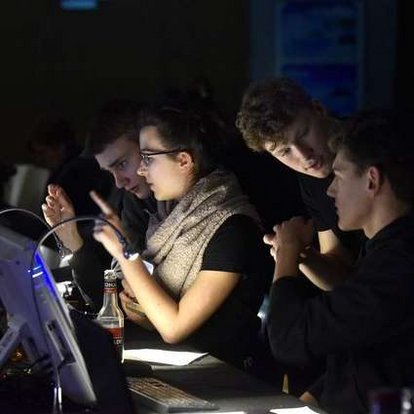 SchülerInnen arbeiten vor Bildschirmen während einer Schulveranstaltung.