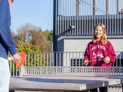 Schülerin spielt Tischtennis auf dem Pausenhof